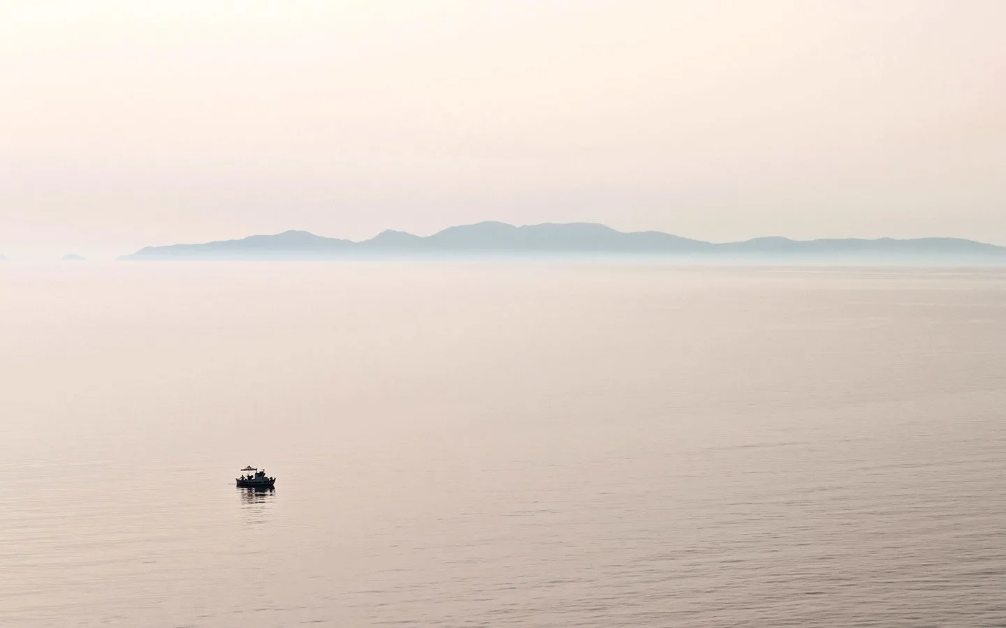 Small boat in the calm seas off Santorini