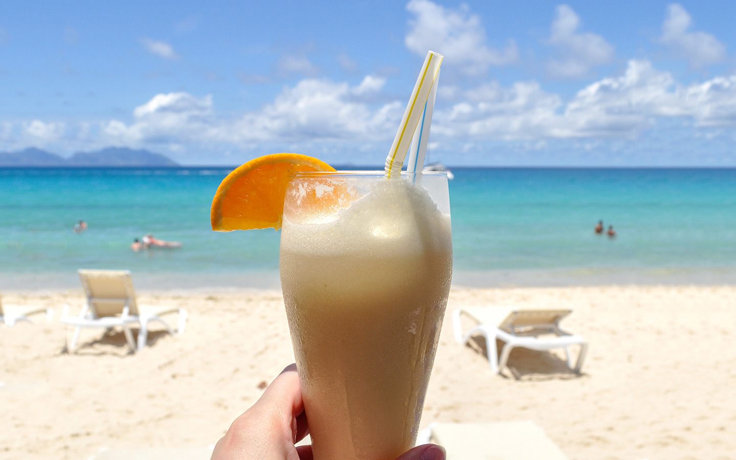 Cocktail on the beach while reading books for travellers