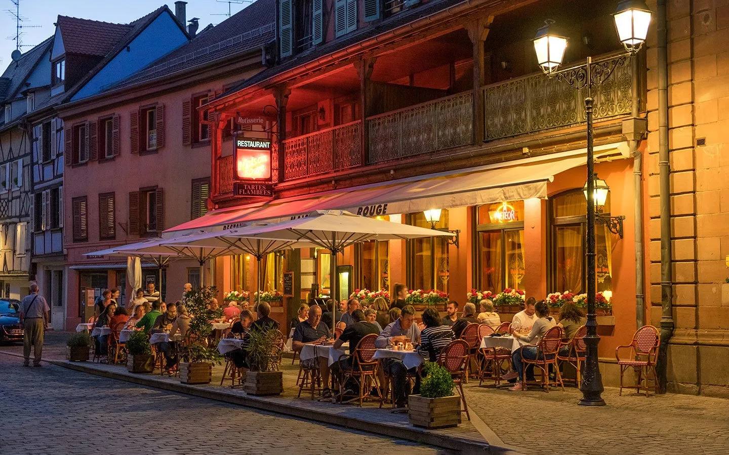 Diners outside a restaurant visiting Colmar, Alsace