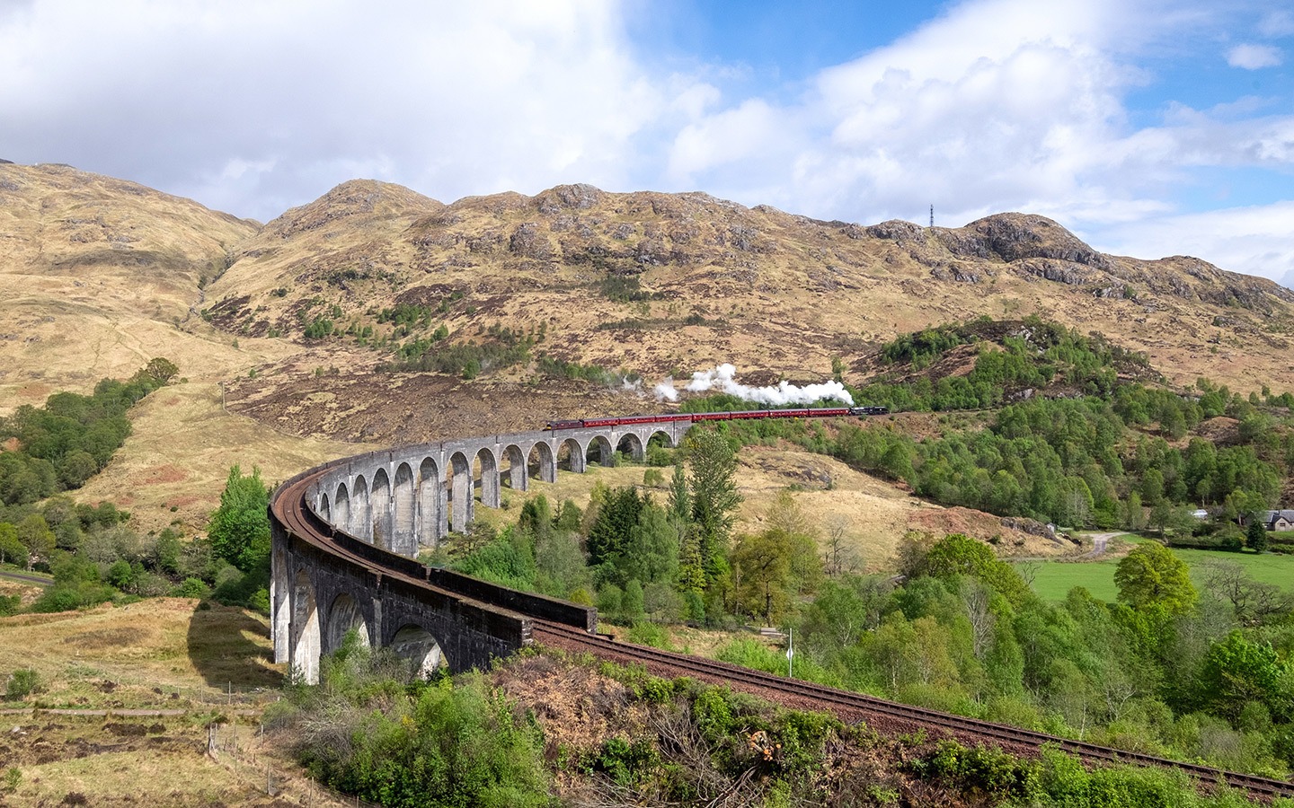 The Jacobite steam train crosses the Glenfinnan Viaduct in Scotland