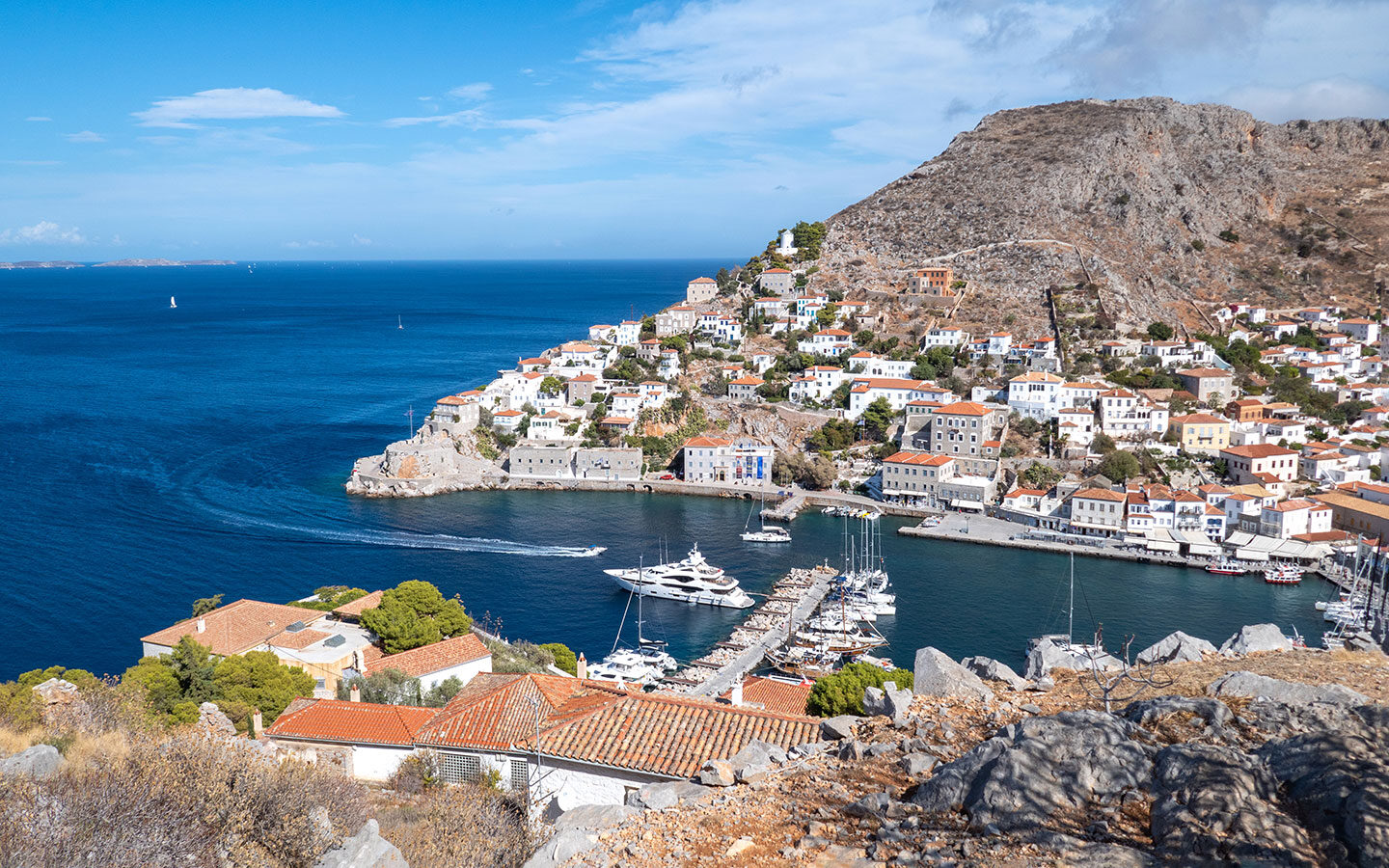 Harbour views from the hilltop Greek flag, one of the best things to do in Hydra Greece