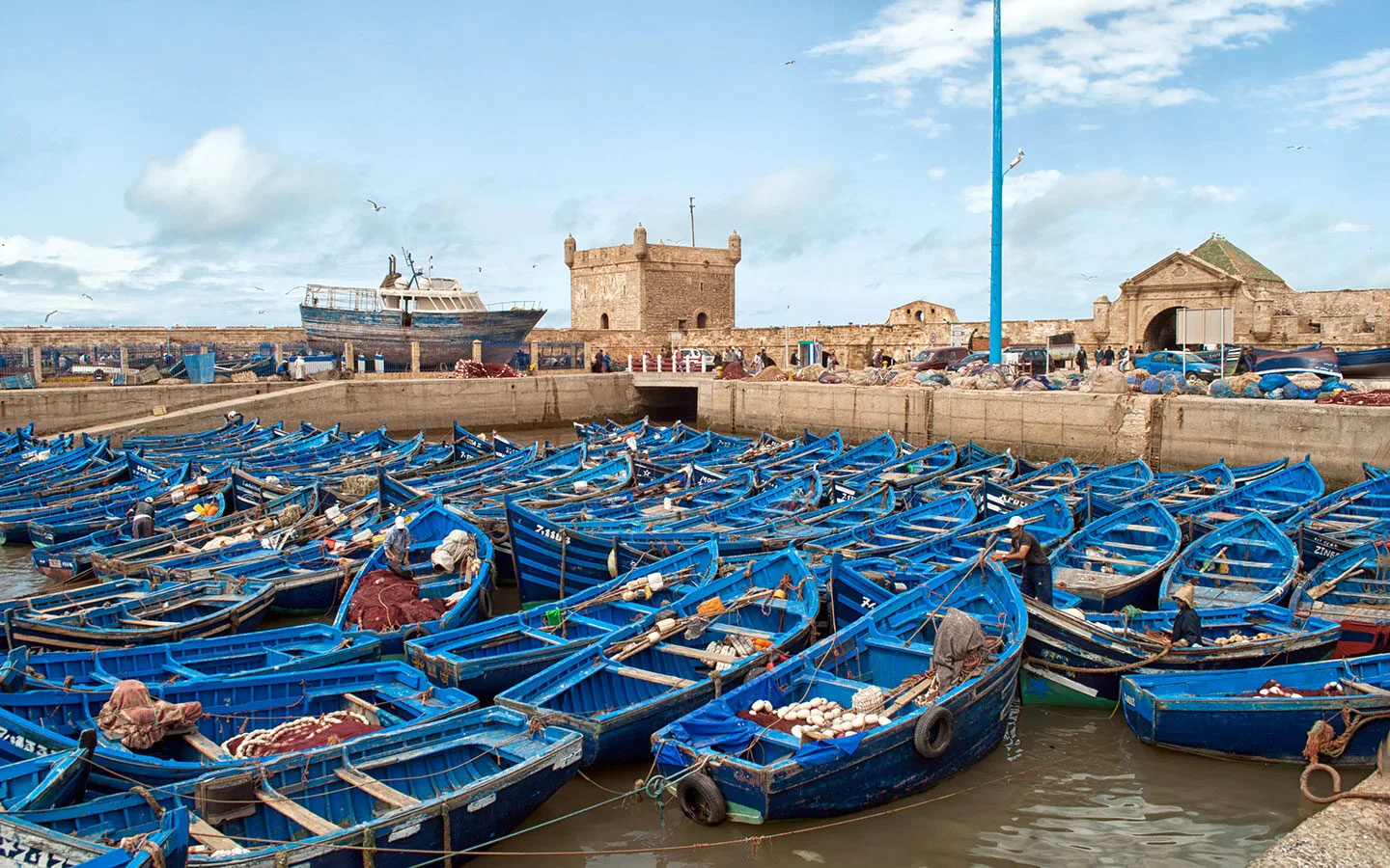 Blue fishing boats lined up next to the Skala du Port in Essaouira