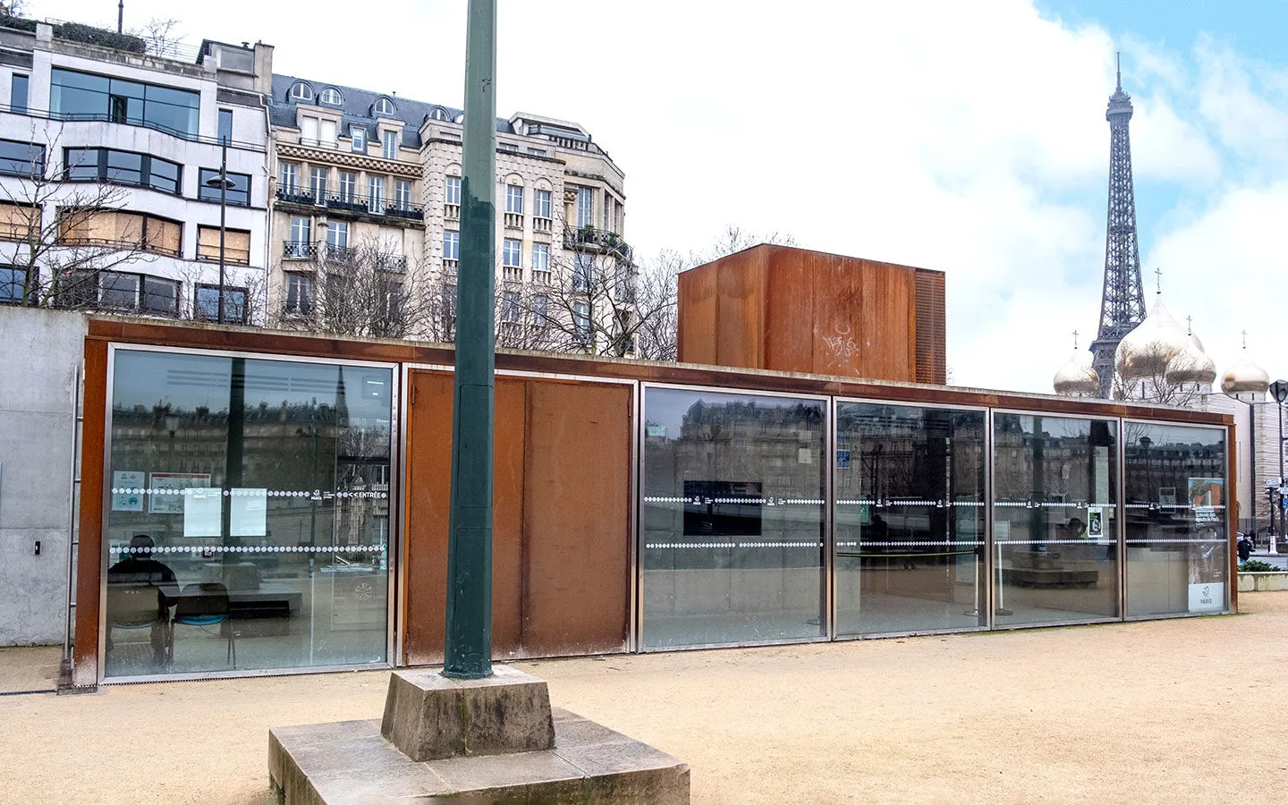 The entrance to the Paris sewer museum with the Eiffel Tower in the background